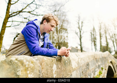 Unglückliche Teenager, beugte sich über ländliche Brücke Stockfoto