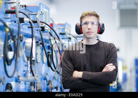 Porträt von Mitte erwachsenen männlichen tragen Gehörschutz in Maschinenfabrik Stockfoto