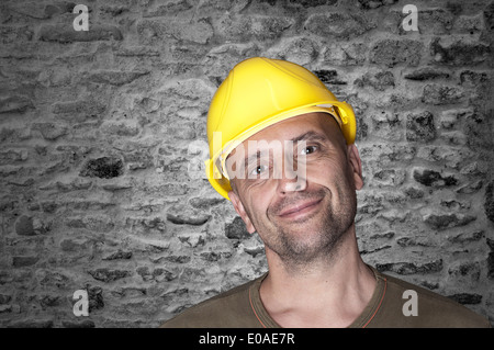 Freundlicher Mann mit gelben Helm auf der Baustelle Stockfoto