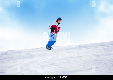 Mann reitet auf dem Snowboard Mountainbike bergab Stockfoto