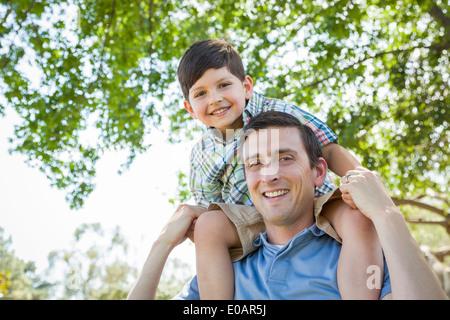 Gemischte Rennen-Vater und Sohn spielen zusammen im Park Huckepack. Stockfoto