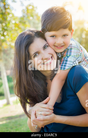 Attraktive junge gemischte Rennen Mutter und Sohn Hug im Freien im Park. Stockfoto