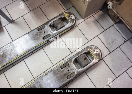 Detail eines Gabelstaplers in einem Lager mit einigen Kartons Stockfoto