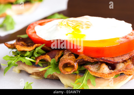 Offenen BLT-Sandwich mit Provolone-Käse, Rucola, Speck, Tomaten und Spiegelei auf Süßkartoffel-Brot Stockfoto