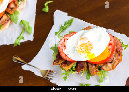 Offenen BLT-Sandwich mit Provolone-Käse, Rucola, Speck, Tomaten und Spiegelei auf Süßkartoffel-Brot Stockfoto