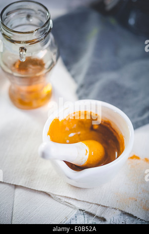 Mixing turmeric powder with honey for turmeric tea Stockfoto