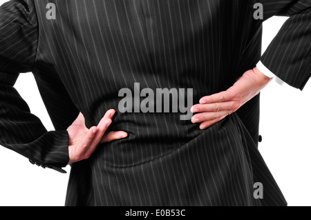 Mann in einem Anzug mit seinen Händen in seinem unteren Rücken wegen seiner Schmerzen im unteren Rücken Stockfoto