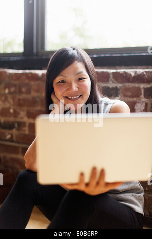 Mitte Erwachsene Frau sitzen auf Etage mit laptop Stockfoto