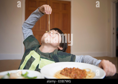 Jungen spielen mit spaghetti Stockfoto