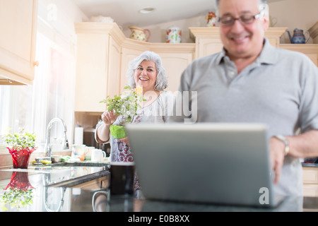 Älteres Paar in Küche mit laptop Stockfoto