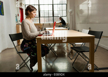 Junge Designerinnen beschäftigt auf Laptop im Designstudio Stockfoto