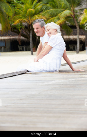 Senior paar sitzt am Holzsteg Stockfoto