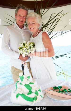 Senior-Strand-Hochzeits-Zeremonie mit Kuchen im Vordergrund Stockfoto