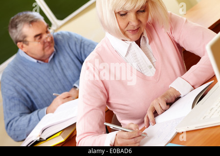 Porträt von Reife Frauen machen Notizen in Copybook mit senior woman auf Hintergrund Stockfoto