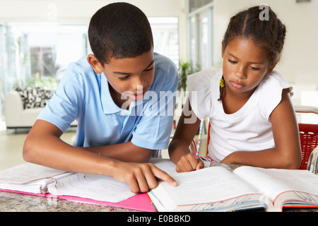 Zwei Kinder Hausaufgaben zusammen In der Küche Stockfoto