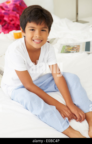 Junge auf Bett liegend In Pyjamas zusammen Stockfoto
