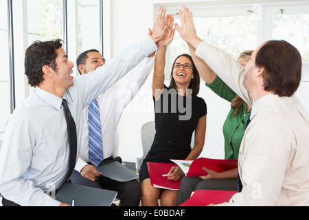 Business-Team geben einander hoch fünf Stockfoto