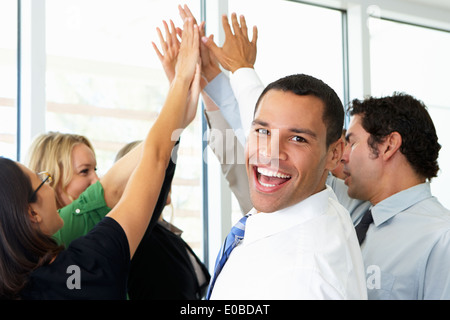 Business-Team geben einander hoch fünf Stockfoto