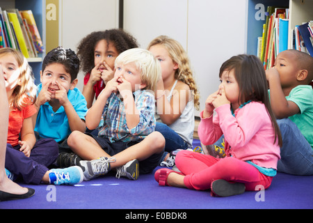 Gruppe von elementaren Schülern im Klassenzimmer, die Nase zu berühren Stockfoto