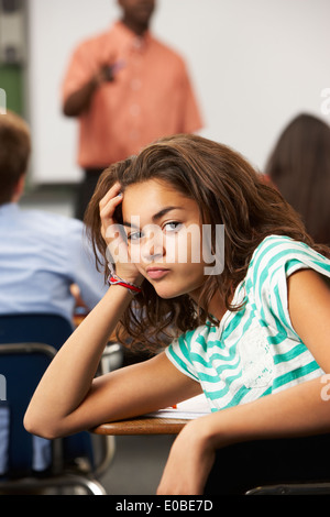 Gelangweilte weibliche Teenager Schüler im Klassenzimmer Stockfoto