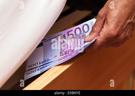 Eine Menge von Euro Banknoten sind versteckt unter dem Bett., Viele Euro-Geldscheine Werden Unter Dem Bett Versteckt. Stockfoto