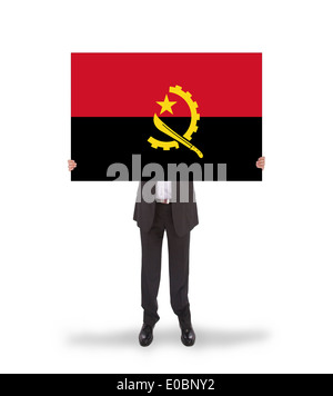 Geschäftsmann hält eine große Karte Fahne Angola isoliert auf weiss Stockfoto