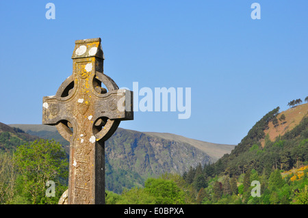 Keltisches Kreuz gegen blauen Himmel und Green Valley Stockfoto