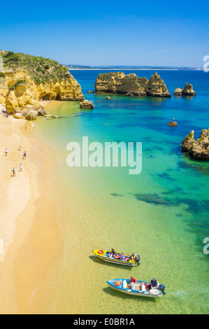 Urlauber und Touristenboote am Strand von Praia da Dona Ana Sandstrand in der Nähe der Ortschaft Lagos Algarve Portugal EU Europa Stockfoto