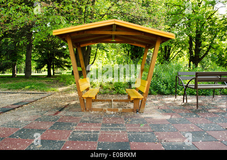 Pergola aus Holz lackiert gelbe Verglasung gebaut im park Stockfoto