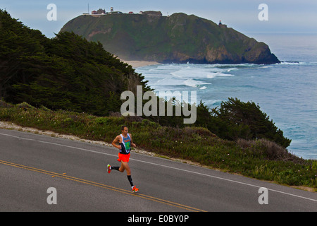 Läufer passieren den Point Sur Leuchtturm während der 2014 Big Sur Marathon - BIG SUR, Kalifornien Stockfoto