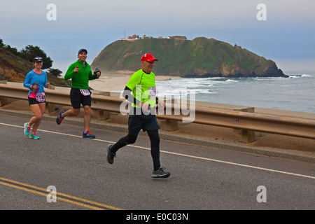 Läufer passieren den Point Sur Leuchtturm während der 2014 Big Sur Marathon - BIG SUR, Kalifornien Stockfoto