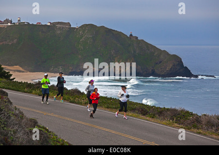 Läufer passieren den Point Sur Leuchtturm während der 2014 Big Sur Marathon - BIG SUR, Kalifornien Stockfoto