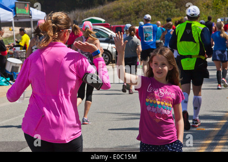 Ein junges Mädchen gibt ein high Five Läufer am Ende 2014 Big Sur Marathon - BIG SUR, Kalifornien Stockfoto