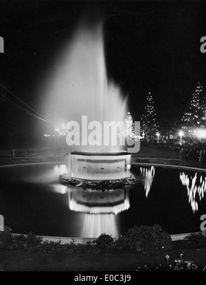 Ein historisches Foto aus der Zeit um 1940, das einen abendlichen Blick auf den Brunnen entlang der Marine Parade in Napier, Neuseeland, zeigt. Das Bild fängt die ruhige Schönheit der Gegend ein und spiegelt den Charme der Küste von Napier während dieser Zeit wider. Stockfoto