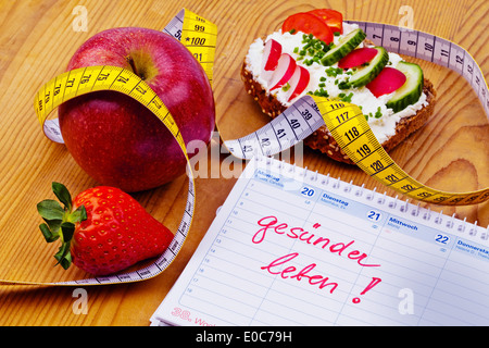 Apple, Dimension Band, Brot mit Gemüse und einen Kalender. Gute Absicht, die gesunde Ernährung, Apfel, Massband, Brot Mit Gemue Stockfoto