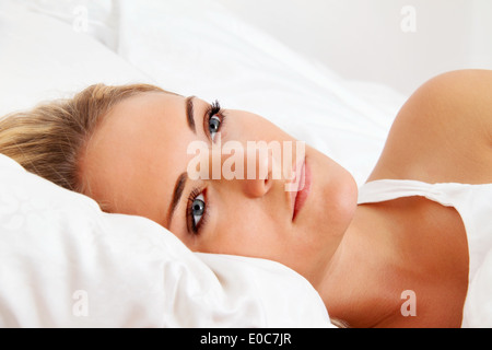 Eine junge Frau liegt wach im Bett. Schlaflos und nachdenklich., Eine Junge Frau Liegt Wach Im Bett. Schlaflos Und nachdenklich Stockfoto