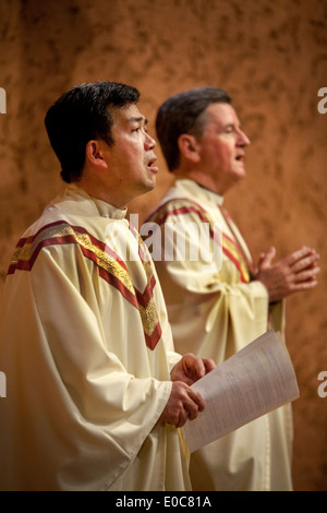 Eine vietnamesische Hilfsprediger und seinem Pastor (rechts) singen Gebete während der Durchführung der Messe in St. Timothy katholische Kirche, Laguna Niguel, CA. Stockfoto