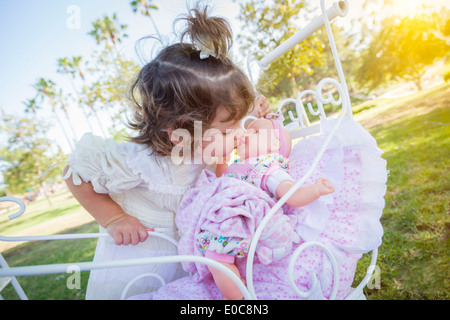 Entzückende junge Baby Mädchen spielt mit ihren Babydoll und Beförderung im Freien. Stockfoto