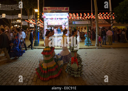 Sevilla, Spanien. 8. Mai 2014. Frauen mit Sevillanas kleiden zu Fuß von der Messe von Sevilla in der Nacht. Bildnachweis: Kiko Jimenez/Alamy Live-Nachrichten Stockfoto