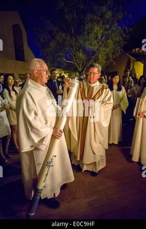 Die Robe Pfarrer der St. Timothy katholische Kirche, Laguna Niguel, CA, Lichter der Osterkerze durch eine ältere Diakon neben dem Osterfeuer zu Beginn der großen Osternacht gehalten. Stockfoto