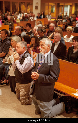 Die Gemeinde kniet im Gebet während der Messe in der St. Timothy katholische Kirche, Laguna Niguel, CA Stockfoto