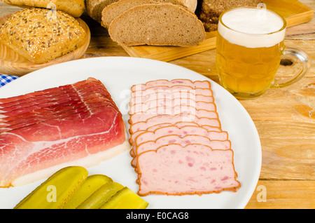 Wurst, eingelegtes Gemüse, Vollkornbrot und Bier, eine traditionelle deutsche kalte Mahlzeit Stockfoto