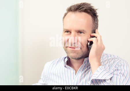 Mann mit einem angenehmen Gespräch auf dem Handy Stockfoto