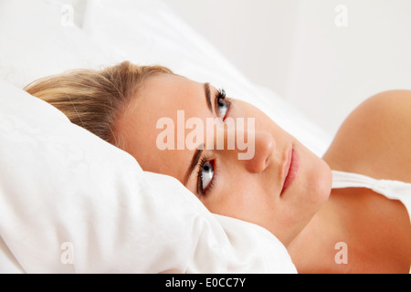 Eine junge Frau liegt wach im Bett. Schlaflos und nachdenklich., Eine Junge Frau Liegt Wach Im Bett. Schlaflos Und nachdenklich Stockfoto