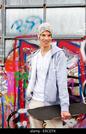 Eine coole junge Mann vor Graffiti, Ein cooles Blickender Jugendlicher Mann Vor Graffiti Stockfoto