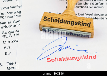 Eine Briefmarke aus Holz liegt an einem Dokument. Label Trennung Kind Stockfoto