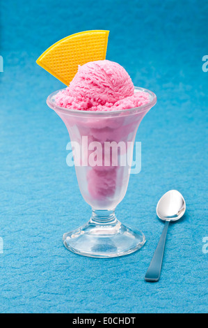 Erdbeer Eisbecher mit Wafer auf blauem Hintergrund Stockfoto