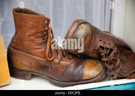 Alte Menschen, gebrauchte Schuhe liegen in einem Schaufenster Stockfoto