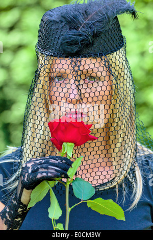 Eine junge, Trauer Witwe mit Schleier und rose Stockfoto