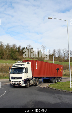 Eine unmarkierte Volvo-Lkw mit einem Textainer Container in einen Kreisverkehr in Coulsdon, Surrey, England Stockfoto